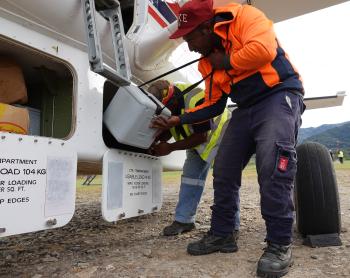 Telefomin traffic officer Ben Peter loading a vaccine eski into the aircraft