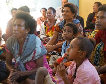 A group of women and girls listen to training