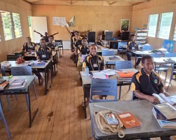 Happy students in classroom at Mougulu Secondary School with new chairs