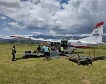 MAF plane on the ground in Goroka with playground materials loaded