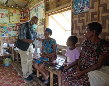 CHW Jamie Gudego examining a patient in his aidpost