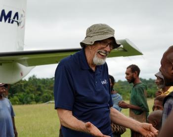 Dan Shaw at Honinabi talking with the local CHW next to the MAF aircraft