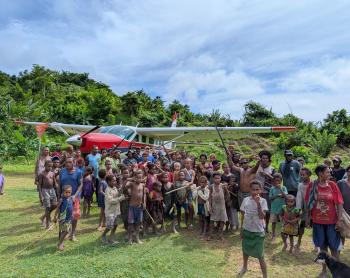 P2-AHP after its first landing at Moka airstrip with people joyfully gathered around the plane