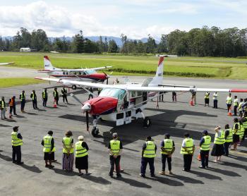 MAF's new Cessna Caravan P2-AFD arriving in PNG and surrounded by MAF staff in a prayer circle