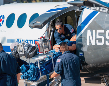 Esther Dii helping a medevac patient out with her team