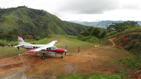 One MAF plane situated on the top of the Owena Airstrip with mountains in the background