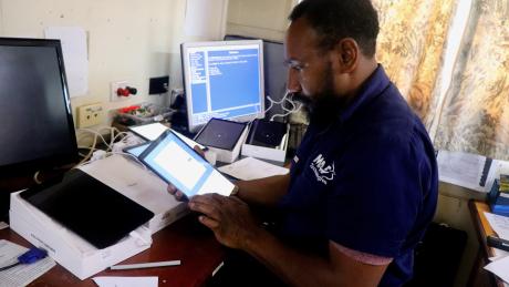 .MAF Technologies IT officer, Ishmael Doroware, Installing translation software into the Wycliffe Tablets prior to distribution.