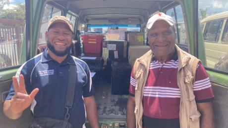 Issac Kaupa and Joe Korim are standing in front of their car filled with medical supplies