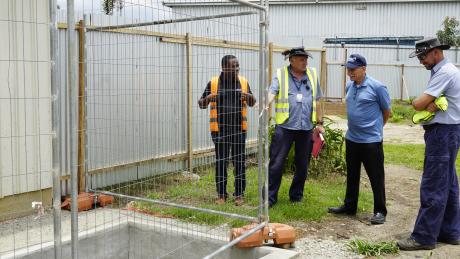 Dave Moore (left middle) explaining the sewage system to MAFI CEO Dave Fyock (right middle), Regional Director Samuel Okposin (left), and Brad Venter (Chief Pilot).