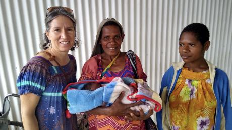 Michelle Venter with 2 Goroka ladies from Mama Care Ministry, holding a newborn baby.