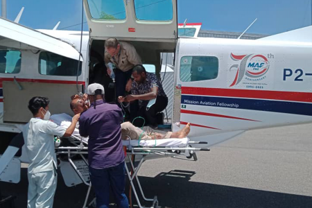 Medevac received in Port Moresby and patient getting transfered to ambulance stretcher