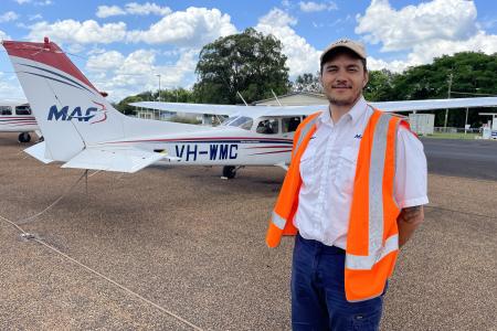 Erwin Jungen posing in front of a plane at the Mareeba Training Centre