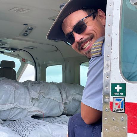 Ryan Cole in the process of loading bales of mosquito nets into the Cessna Caravan