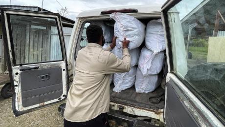 RAM project officer loading mosquito nets delivered to the Telefomin MAF base for further distribution