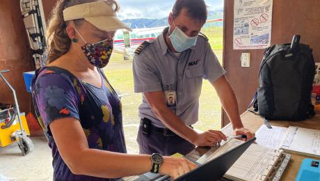 Siobhain Cole brriefing pilot Piet Muilwijk on his day's flying to deliver mosquito nets