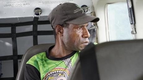 Senior Project Officer Fidelis Nick on board a MAF plane looking out the window