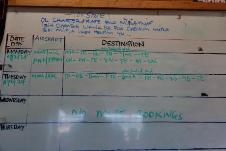 whiteboard with flight schedules at Telefomin Base