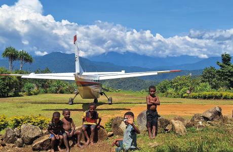 Pyarulama airstrip with a MAF plane ready for take-off and a few kids watching