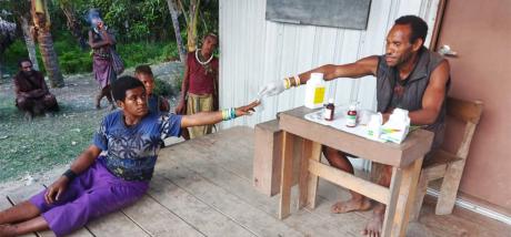 Yanis handing out medicine in front of the clinic