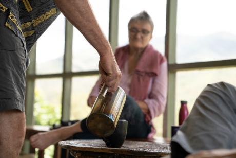 Dr. Mills pours coffee for Jutta Werdes and Hanno Allolio while discussing the Kompiam Hospital.