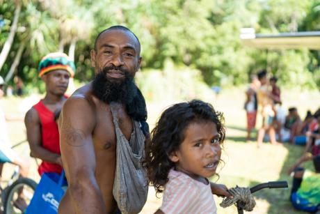 Harry and his daughter Calvin, residents of Wuvulu, smile for a photo while enjoying the shade provided by the MAF plane's wing.