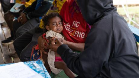 A child is tested by a BMH team member for malaria at the Indagen health clinic.