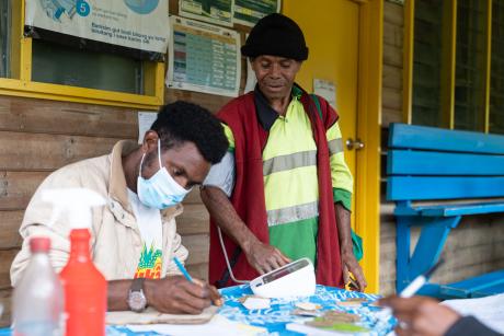 Indagen Health Clinic worker Jack Wama checks Joel Salnuka's blood pressure outside the clinic.