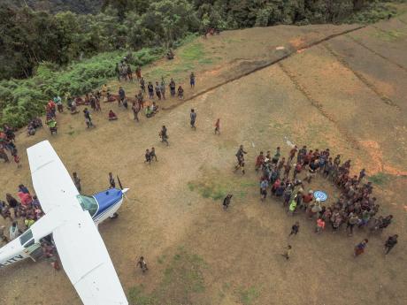 The Dimanbil people gather at the runway to celebrate the first landing of an aircraft.