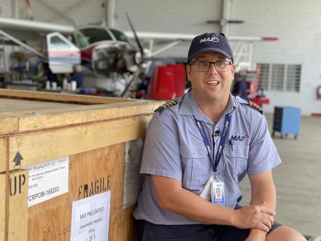 Pilot Tim Neufeld in front of the still closed crate in the MAF hangar