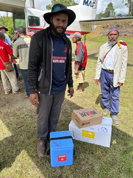 Saki Tato ready to board the plane with his vaccination cooler box and other supplies - but the weather didn't allow for a landing that day at his destination