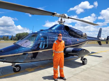 Manolos Aviation Pilot Jan Henning standing beside Manolos helicopter.