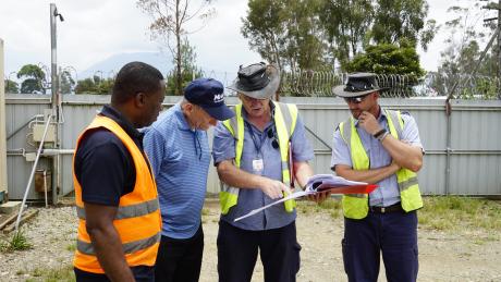 Dave Moore (right middle) showing new project plans to Regional Directory Samuel Okposin (left), MAFI CEO Dave Fyock (left middle), and Chief Pilot Brad Venter (right).