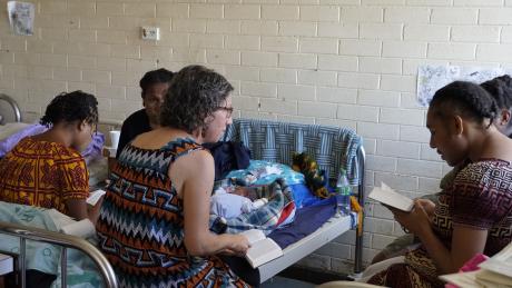 Michelle Venter sitting with local ladies at Goroka Hospital, pointing at her Bible.