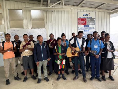 grade 12 students singing a song a MAF's morning devotion