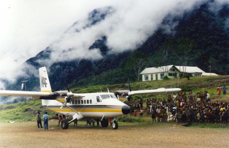 A plane at a remote mountain airstrip with local people