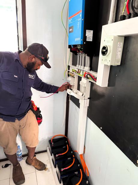 Nason Lukio, Lead Technician, installs the inverter and connects the battery at Han Clinic.