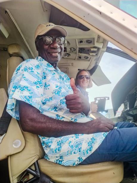 A man sits next to the pilot in a small plane
