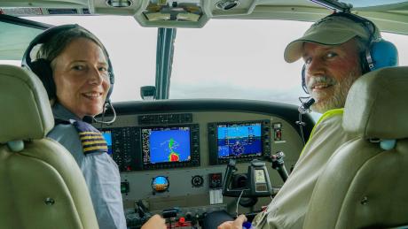A pilot and passenger in the cockpit of a plane