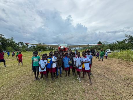 Children on an airstrip with a plane