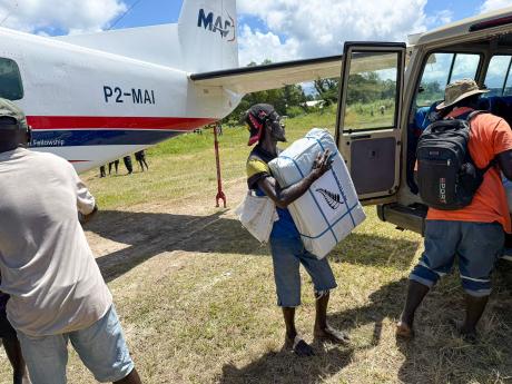 A man unloads aid supplies from a small plane